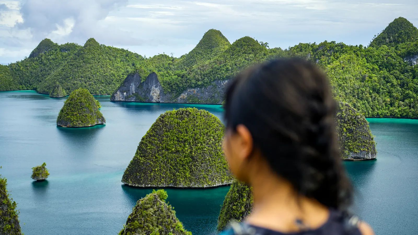 Nomad Archipelago liveaboard – guest viewing karst islands from a lookout – Indonesia