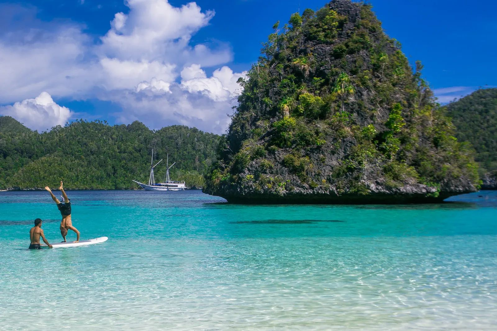 Katharina liveaboard – guests doing a handstand on a paddleboard near limestone islands – Indonesia