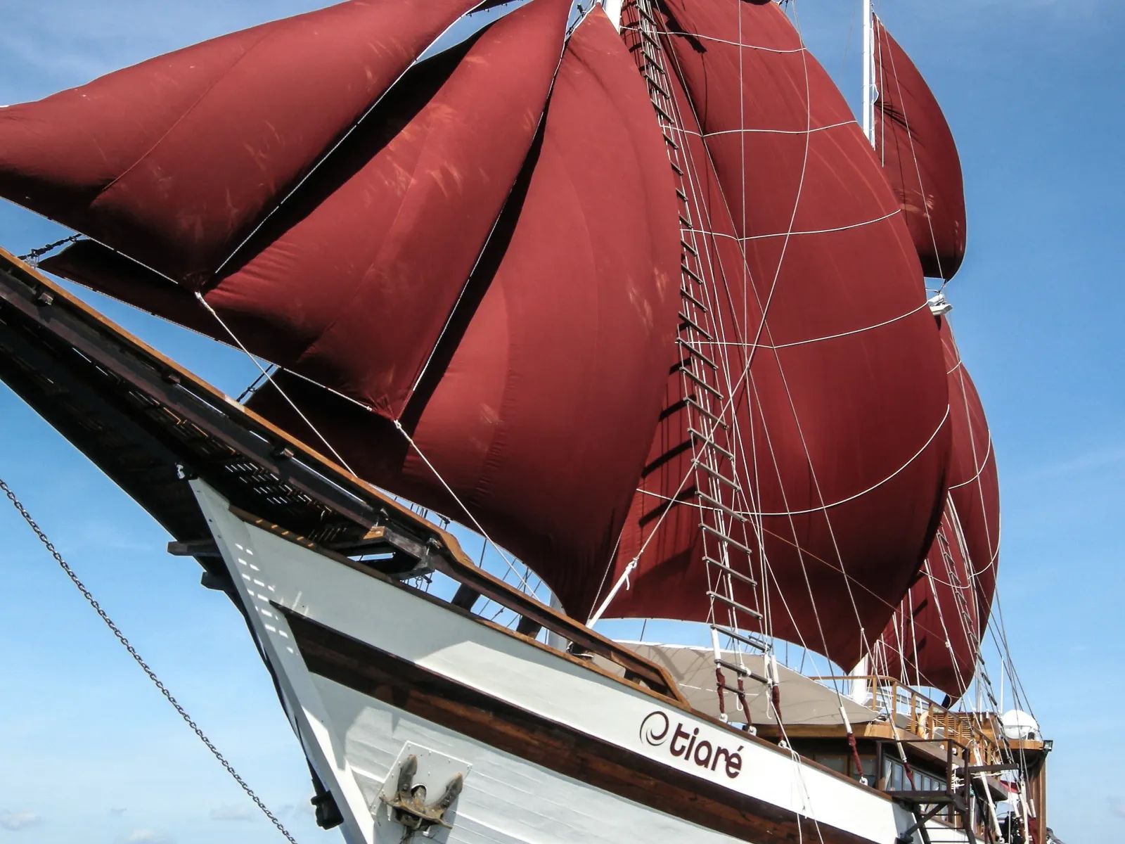 Tiaré liveaboard – bow and red sails from deck level – Indonesia